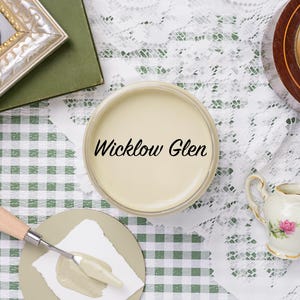 May include: A still life arrangement featuring a paint can labeled "Wicklow Glen", a palette knife with paint, and a small decorative creamer with a floral design. A vintage clock and framed mirror are also present.
