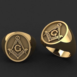 May include: Two gold rings with a Masonic symbol engraved on the face. The symbol is a compass and square with a 'G' in the center.