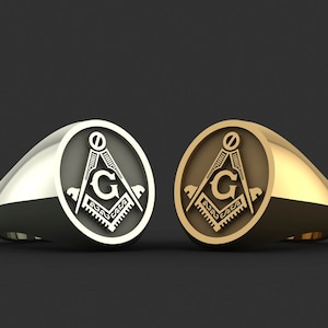 May include: Two rings with a Masonic symbol, one silver and one gold. The symbol is a compass and square with a 'G' in the center.
