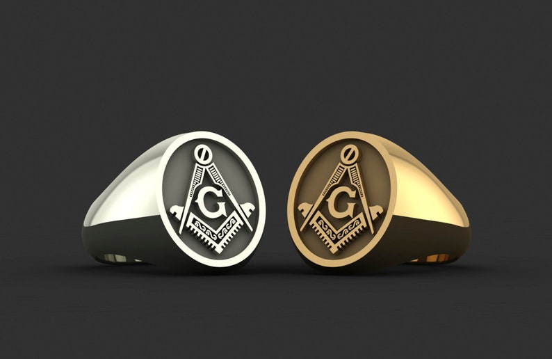 May include: Two rings with a Masonic symbol, one silver and one gold. The symbol is a compass and square with a 'G' in the center.