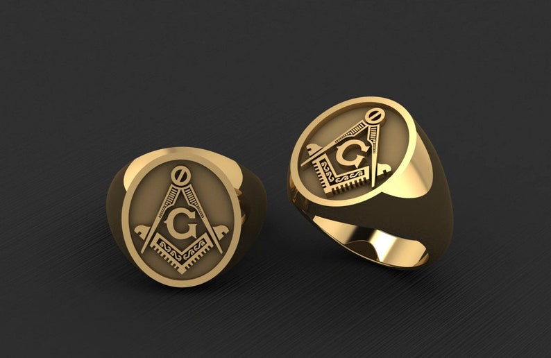 May include: Two gold rings with a Masonic symbol engraved on the face. The symbol is a compass and square with a 'G' in the center.