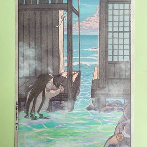 May include: A woodblock print showing a woman bathing in a natural hot spring. The woman is seated in the water, which is a vibrant green colour. The water is surrounded by rocks and a wooden structure. The background shows a view of the ocean and sky.