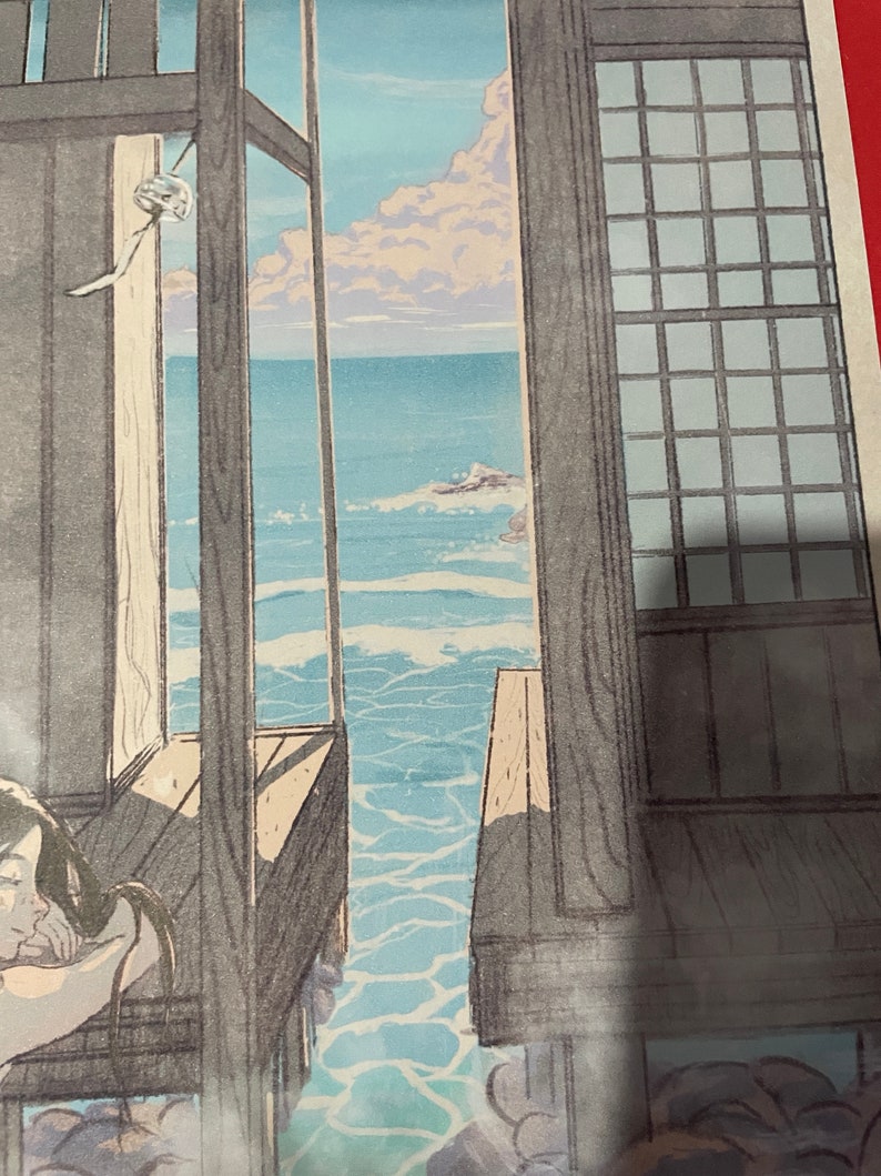 May include: A wooden-framed window with a view of the sea. The water is a light blue colour and there are white clouds in the sky. The window is open and the sea is visible through the opening.