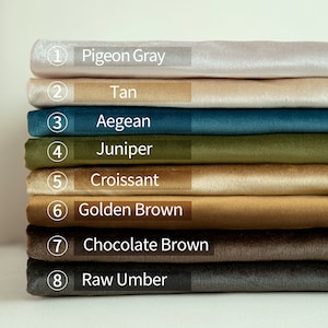 May include: A stack of eight fabric swatches in various colors, including Pigeon Gray, Tan, Aegean, Juniper, Croissant, Golden Brown, Chocolate Brown, and Raw Umber. Each swatch is labeled with its color name.