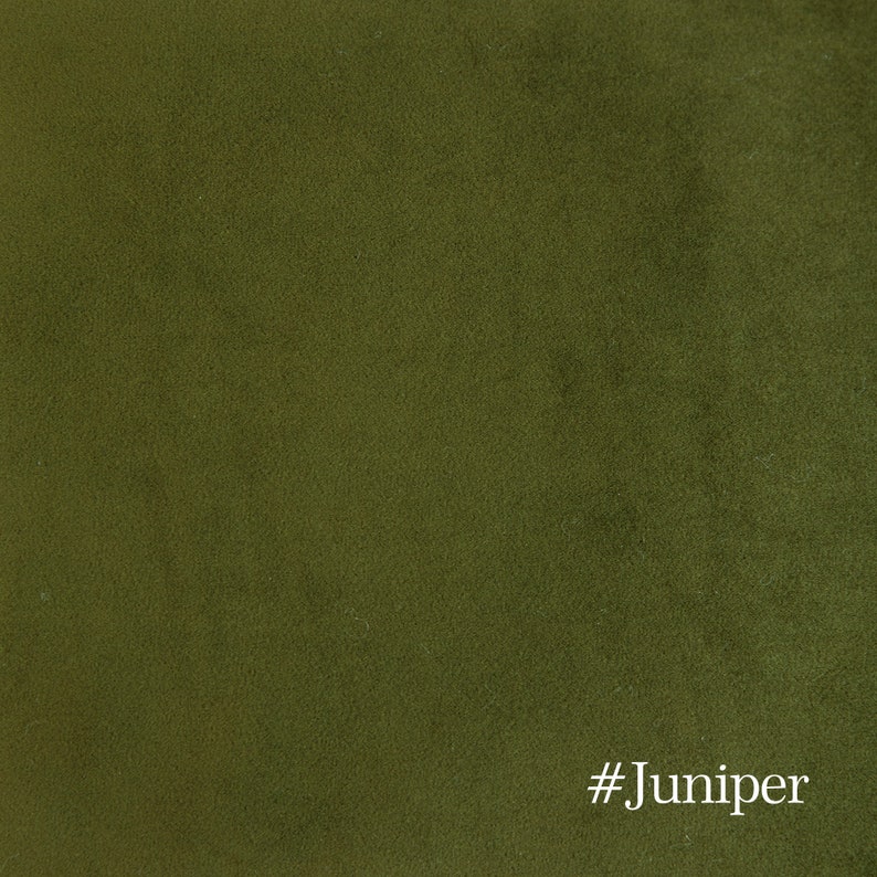 May include: Close-up of a textured fabric in a deep olive green color. The fabric has a soft, velvety appearance. The text "#Juniper" is in the bottom right corner.