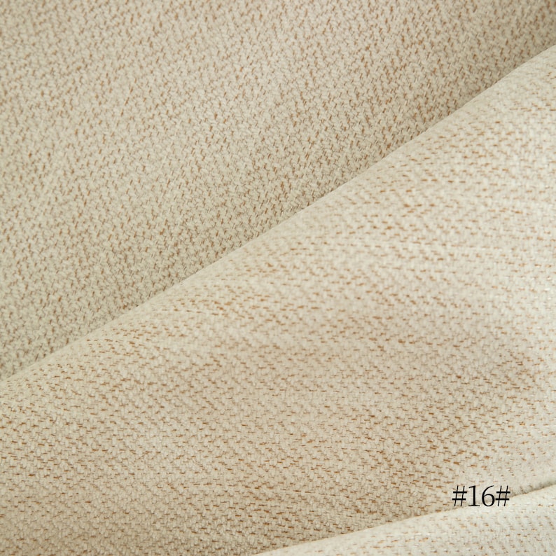 May include: Close-up of a beige fabric with a subtle textured pattern. The fabric is folded in half, creating a diagonal line. The text "#16#" is visible in the bottom right corner.