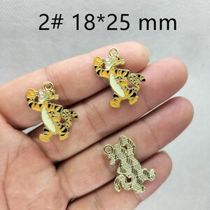 May include: Three Tigger-shaped charms. Two are yellow with black stripes and white bellies, and one is gold-colored with a textured pattern. The charms are approximately 0.7 x 1 inch in size. The text "2# 18*25 mm" is at the top.