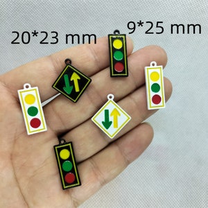 Pu&ograve; includere: Assortimento di sei ciondoli in metallo con semafori e segnali stradali. I ciondoli misurano 20 mm x 23 mm e 9 mm x 25 mm. I ciondoli sono bianchi, neri, verdi, rossi e gialli.