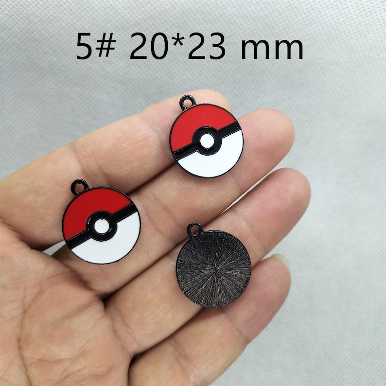 May include: Five 20mm by 23mm metal charms with a red and white Pokeball design and one black charm with a textured surface.
