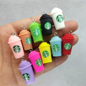 May include: Assortment of 10 colorful miniature plastic cups with a white lid and a green Starbucks logo. Each cup has a silver loop for hanging.