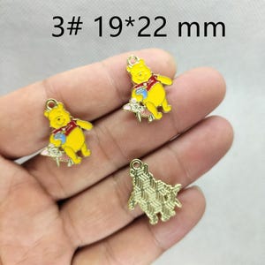 May include: Three Winnie the Pooh charms. The yellow charms have red vests and blue cups. The charms are 19mm x 22mm. The text "3# 19*22 mm" is in the image.