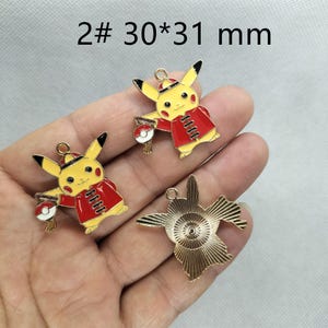 May include: Two gold-colored metal charms featuring a cartoon character wearing a red and gold Chinese-style outfit. The charms are 30mm by 31mm in size. The text "2# 30*31 mm" is visible in the image.