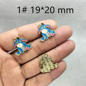 May include: Three blue and white enamel charms in the shape of a donkey with pink accents and gold-colored trim. The charms are approximately 0.75 x 0.79 inches. The text "1# 19*20 mm" is visible in the image.