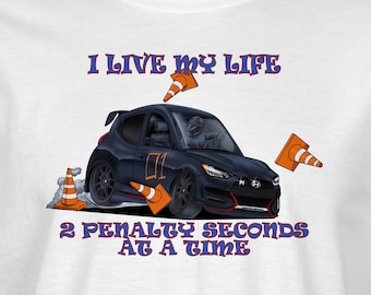 May include: White t-shirt with a black cartoon car and orange cones. The text on the shirt reads "I live my life 2 penalty seconds at a time".