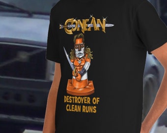 May include: A black t-shirt with a graphic of a cartoon Conan the Barbarian holding a sword and standing on a traffic cone. The text "Conan" and "Destroyer of Clean Runs" is printed on the shirt.