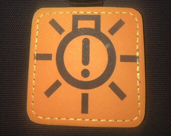 May include: Orange keychain with a black warning light icon and a silver key ring.