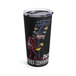 May include: Black tumbler with a silver lid featuring a cartoon image of a racer hugging a drag racing Christmas tree. The racer is wearing a red racing suit and helmet. Text on the tumbler reads "I'm a tree hugger".