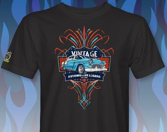 May include: Black t-shirt with a vintage car graphic. The car is blue and white with red and orange accents. The graphic also includes the text "Vintage Automotive Legend Est. 1955".