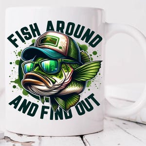 May include: White ceramic coffee mug with a green, black, and white illustration of a bass fish wearing sunglasses and a baseball cap. The text "Fish Around And Find Out" is printed on the mug.
