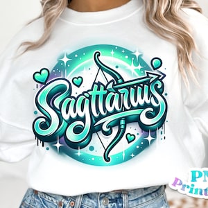 Pode incluir: Uma camisa de moletom branca com um design gr&aacute;fico azul-turquesa e roxo da palavra "Sagit&aacute;rio" com uma flecha e um arco. O design &eacute; cercado por um c&iacute;rculo de estrelas e cora&ccedil;&otilde;es.