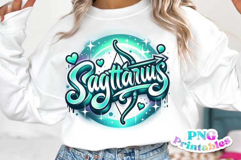 Pode incluir: Uma camisa de moletom branca com um design gr&aacute;fico azul-turquesa e roxo da palavra "Sagit&aacute;rio" com uma flecha e um arco. O design &eacute; cercado por um c&iacute;rculo de estrelas e cora&ccedil;&otilde;es.