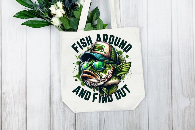 May include: White canvas tote bag with a green, black, and blue illustration of a bass fish wearing sunglasses and a hat. The text "Fish Around And Find Out" is printed on the bag.