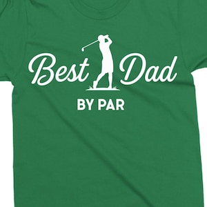 K&ouml;nnte beinhalten: Gr&uuml;nes T-Shirt mit dem Text "Best Dad" in Schreibschrift und einer Silhouette eines Golfspielers beim Schwingen eines Schl&auml;gers. Darunter steht "BY PAR" in einer serifenlosen Schriftart. Das Shirt hat eine einfarbige gr&uuml;ne Farbe.