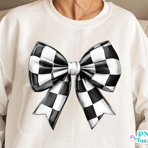 May include: A white sweatshirt with a black and white checkered bow design.