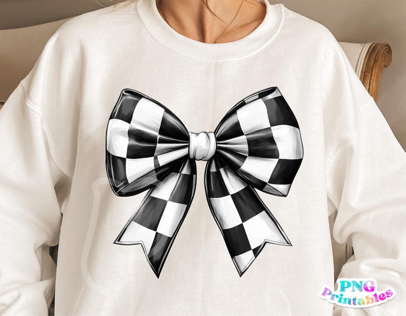 May include: A white sweatshirt with a black and white checkered bow design.
