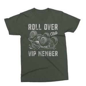 May include: Dark green t-shirt with the words "ROLL OVER Club VIP MEMBER" in white, above a graphic of a buggy flipped over. The design is distressed, giving it a vintage look.