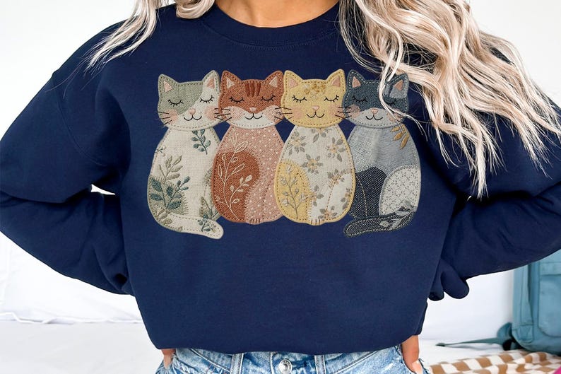 Pu&ograve; includere: Felpa blu navy con quattro applicazioni di gatti stilizzati. Ogni gatto ha un motivo unico, tra cui disegni floreali e di foglie, nei toni del crema, marrone, giallo e grigio. I gatti sono disposti in fila, con gli occhi chiusi, creando un'estetica accogliente e stravagante.