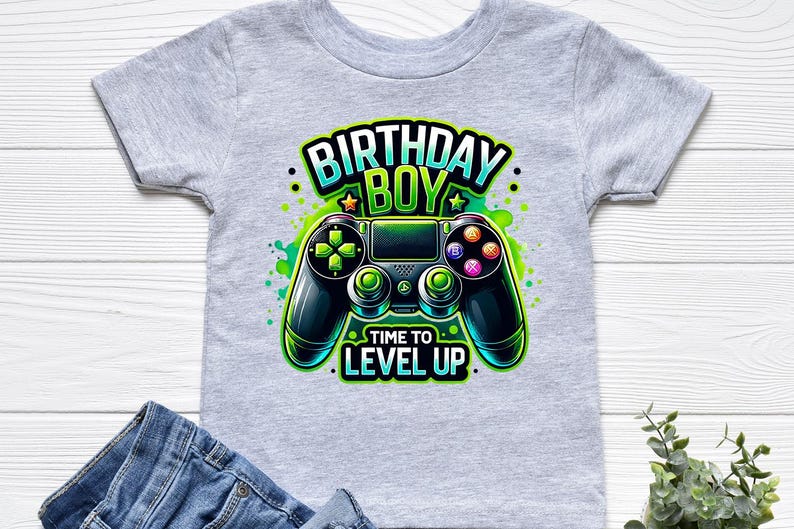 May include: Gray t-shirt with a green and black video game controller graphic. The text "Birthday Boy" and "Time to Level Up" is printed on the shirt.