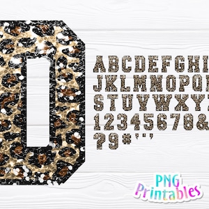 May include: Leopard print alphabet letters and numbers in a varsity style font. The letters and numbers are gold and black with a glittery finish. The letters are uppercase and the numbers are in a standard font.