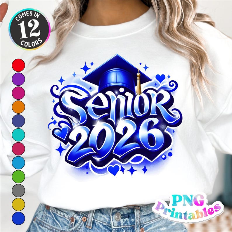 K&ouml;nnte beinhalten: Wei&szlig;es Langarmshirt mit blau-wei&szlig;em Design mit der Aufschrift "Senior 2026". Das Design umfasst eine Abschlusskappe, Herzen und Sterne. Das Shirt ist in 12 Farben erh&auml;ltlich.