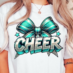 May include: White t-shirt with a blue and gold bow and the word "CHEER" in a stylized font.