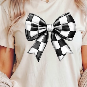 May include: A white t-shirt with a black and white checkered bow design.