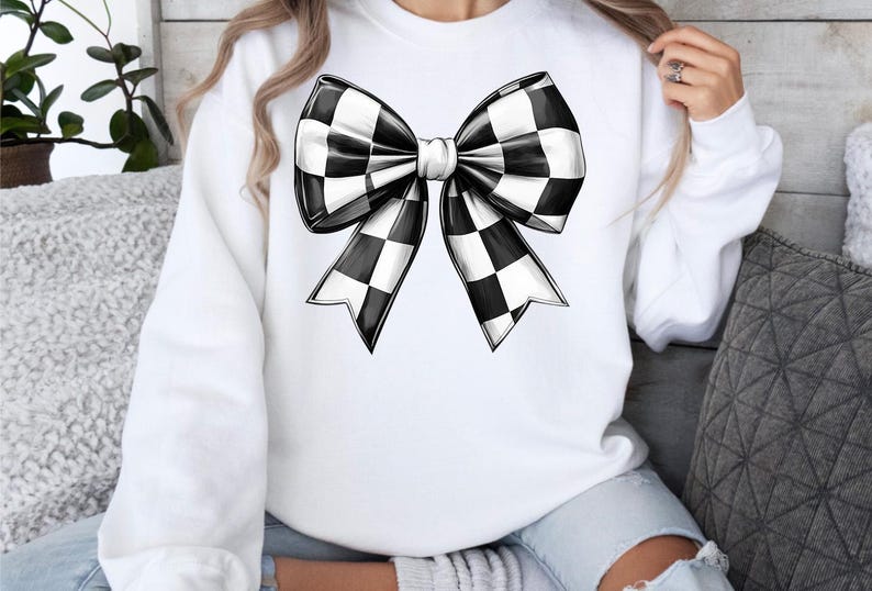 May include: White sweatshirt with a black and white checkered bow design.