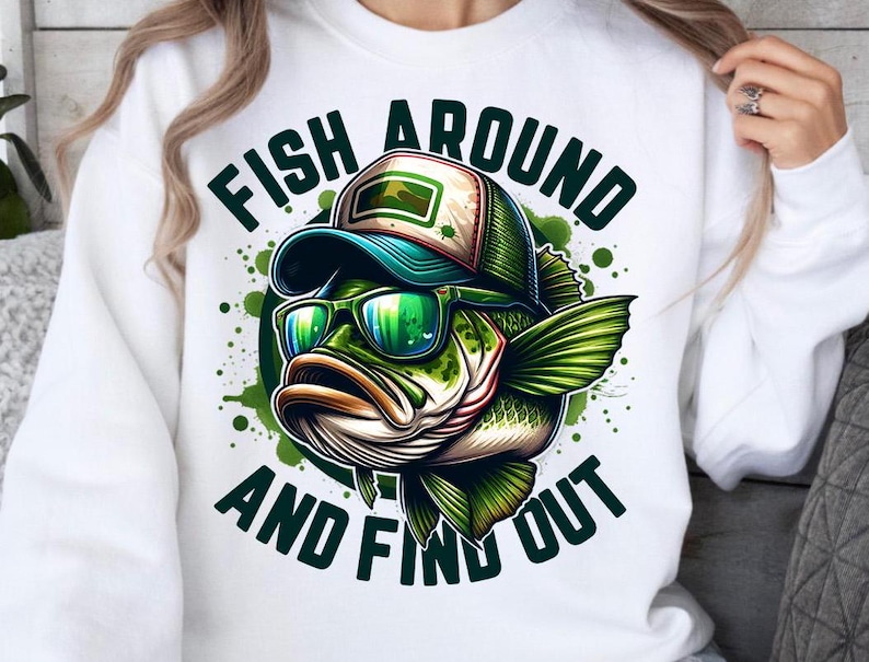 May include: White sweatshirt with a green and black illustration of a fish wearing a hat and sunglasses. The text "Fish Around And Find Out" is printed on the shirt.