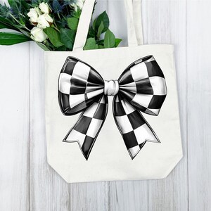 May include: A white tote bag with a black and white checkered bow design.