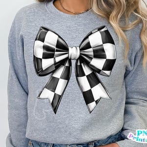 May include: A gray sweatshirt with a black and white checkered bow design.