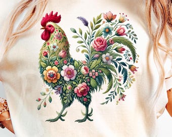 May include: A white t-shirt with a colorful rooster design. The rooster is made of flowers and leaves, and it is standing on a white background.