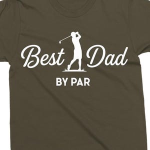 K&ouml;nnte beinhalten: Olivgr&uuml;nes T-Shirt mit wei&szlig;em Schriftzug "Best Dad BY PAR" und einer Golfspieler-Silhouette. Dieses l&auml;ssige Shirt ist f&uuml;r Golf-Enthusiasten gedacht.