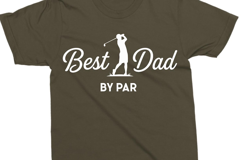 K&ouml;nnte beinhalten: Olivgr&uuml;nes T-Shirt mit wei&szlig;em Schriftzug "Best Dad BY PAR" und einer Golfspieler-Silhouette. Dieses l&auml;ssige Shirt ist f&uuml;r Golf-Enthusiasten gedacht.