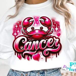 Pode incluir: Uma camisa de moletom branca com um design gr&aacute;fico rosa e preto de um caranguejo e a palavra "C&acirc;ncer". O design &eacute; cercado por cora&ccedil;&otilde;es e estrelas rosas.