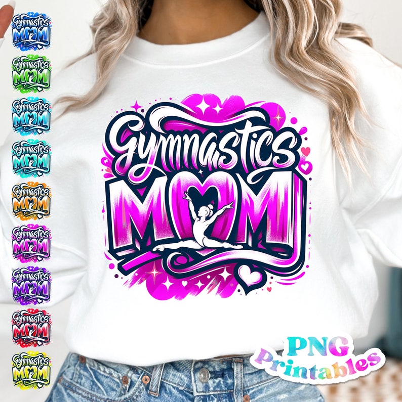 Op de afbeelding: Wit sweatshirt met een roze en paarse grafische print met de tekst "Gymnastics Mom" en een silhouet van een turnster in een hartvorm. Het ontwerp is omringd door sterren en harten.