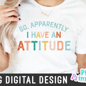 May include: A white t-shirt with the text "So, Apparently I Have An Attitude" in colorful, distressed lettering.