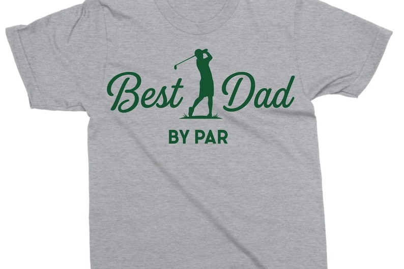 K&ouml;nnte beinhalten: Hellgraues T-Shirt mit dem gr&uuml;nen Schriftzug "Best Dad" und einer gr&uuml;nen Silhouette eines Golfspielers. Der Text "BY PAR" befindet sich unter dem Haupttext.