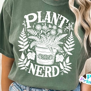 Może przedstawiać: Zielona koszulka z białym nadrukiem przedstawiającym roślinę w doniczce i tekstem "PLANT NERD".