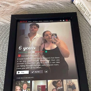 May include: A framed print featuring a Netflix-themed design with a couple's photo and the text "6 years." The black frame surrounds the image, which includes a screenshot with text and additional photos.