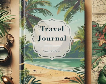 Op de afbeelding: Een hardcover reisdagboek met een tropische strandscène op de omslag. De omslag toont palmbomen, een zandstrand en de tekst "Travel Journal" in een decoratief kader, met de naam "Sarah O'Brien" eronder.